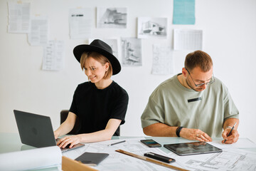 Fototapeta premium Young creative designers girl and guy develop project in the office. Photo for ad educational courses or design services