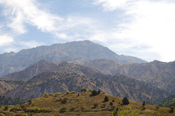 The beautiful mountain landscape of Uzbekistan on the background of white clouds, mountains Beldersay.