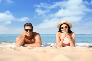 Fototapeta premium Happy couple resting on sunny beach at resort