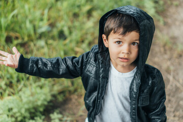 high angle view of cute boy in black jacket looking at camera