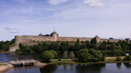 Fototapeta na wymiar An ancient fortress by the river. Ivangorod, Russia. View from the side of Narva, Estonia.