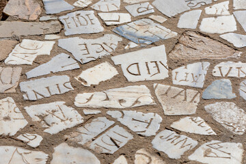 Old pavement made of marble pieces with latin letters illustrating difficullties of information...