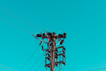electric pole and blue sky. cables with lines, transformers and hots. electricity and energy concept photo