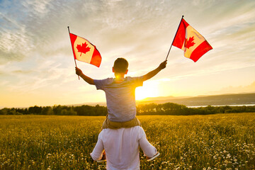 Schattige schattige gelukkige blanke jongen met Canadese vlag op de schouder van de vader
