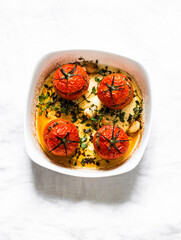 Tomatoes stuffed with meat, baked in the oven on a light background, top view