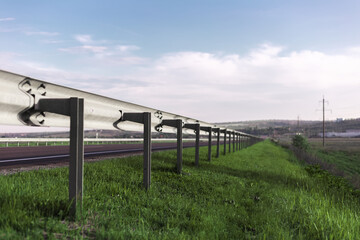 Perspective portrait of road barrier safety fence in sunny day with blue sky.