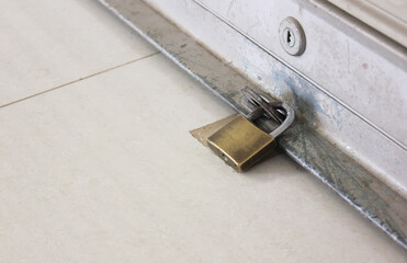 close up locks between the steel rolling shutters door and the lock on the building floor. 