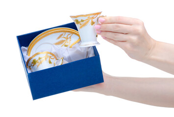 Hand holding coffee cups and saucer in a box on white background isolation