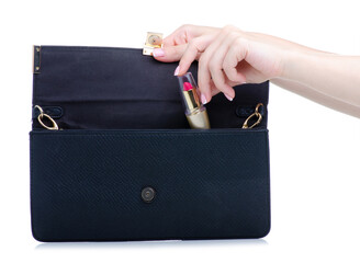 Pink lipstick put in female bag on white background isolation