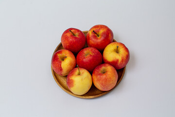 Red apple on the wood plate with white background