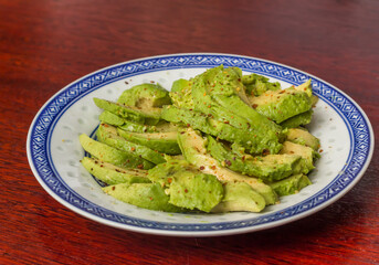 Avocado salad with pepper and lemon juice on a chinese plate