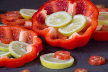 sliced rings of fresh lemon, cherry tomatoes and red bell pepper, close-up
