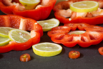 sliced rings of fresh lemon, cherry tomatoes and red bell pepper, close-up
