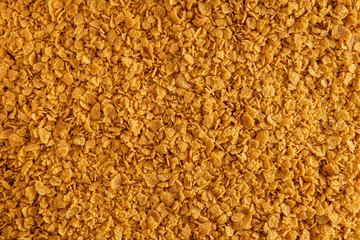 Abstract background of golden breadcrumbs replacement made from yellow gluten-free cornflakes. view...