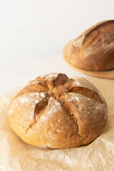 Loaf of homemade bread from wheat and seeds on parchment paper