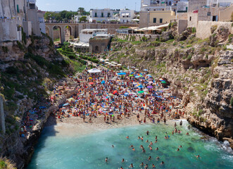 People relax and swimming on lovely beach Lama Monachile in Polignano a Mare