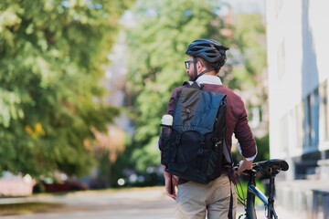 Male commuter or messenger with a bike in urban background. Safe cycling in the city, going to work...