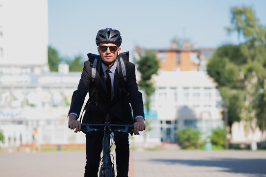 Portrait Of A Male Commuter Riding A Bicycle. Cycling Around The City, Going To Office Work By Bike