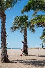 Portrait of man standing near a palm tree on the beach in Valras in south of France