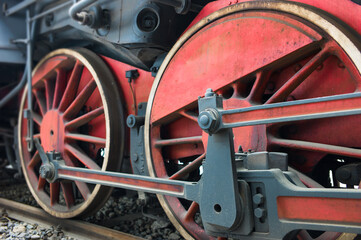 Old red and black locomotive wheels close up. Focus on the right part of the image