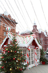 Journey to Christmas Festival 2020 in Moscow city, Russia. New Year's, Christmas decor on street. Christmas market, fair on Manezhnaya Square near Red Square. Red house with candies, sweets. Fir-tree