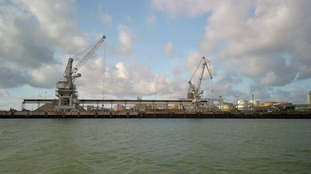 Cranes at Bayonne port as seen from a boat on the estuary of the Adour River, in France