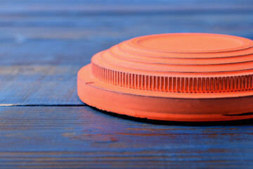 Close-up of orange flying target plate on blue wooden table