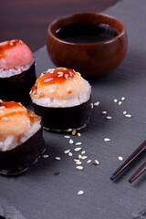 Close-up of sushi rolls wrapped in nori with spicy sauce