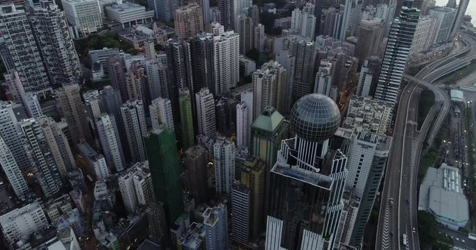 4K UHD car traffic and people crossing road in Hong Kong city downtown. Drone aerial top view, fly upward. Commuter, Asia city life or public transportation concept