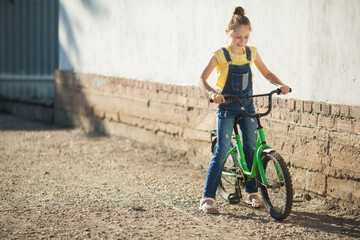 beautiful teenage girl riding a bicycle in summer