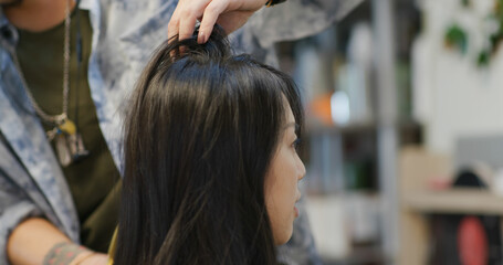 Naklejka premium Woman cut hair in salon