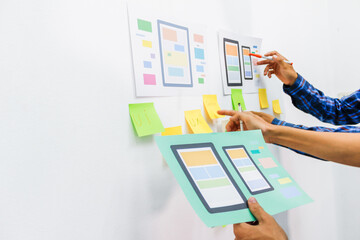 The team of website designers with the ux ui system are writing programs and laying the layer to...