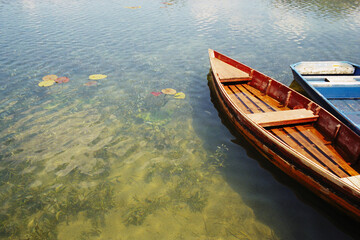 Obraz premium Panoramic view of old flooded fishing boats on a mountain lake in the town of Plav in Montenegro. Real grain scanned film.