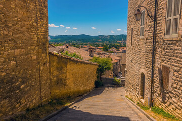 A view down a hillside street in the cathedral city of Gubbio, Italy in summer