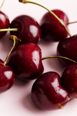 Close up group of sweet cherry berries at flat pink background