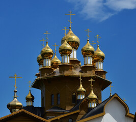 Fototapeta na wymiar Wooden orthodox temple with golden domes