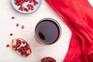 Glass of pomegranate juice on a white concrete background. Top view, close up.