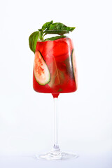 Strawberry lemonade with cucumbers. A glass of lemonade is decorated with a Basil branch. Soft drink. Vertical photo on a white background. Copy of the space.