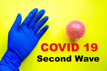 Male hand in a blue medical sterile glove near the core, virus, coronavirus on a yellow background. Copy Space. Covid-19