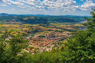 Fototapeta na wymiar A view from the top of the Mount Ingino over the city of Gubbio, Italy towards the Apennine mountains in summer