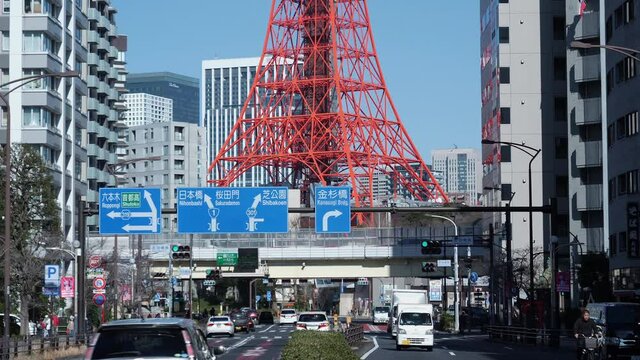  TOKYO, JAPAN - 2020 circa: Tokyo Tower and car traffic at rush hour, medium shot. Filmed in 4K during a nice sunny day.