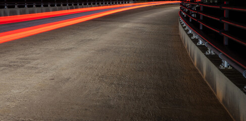 Long exposure, Light Trail of a car’s taillight on a bridge at night