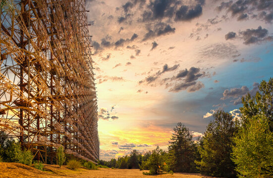 Huge duga radar complex in the chernobyl exclusion zone. Warm orange summer day, late afternoon golden sunset. Red colored sky indicating recent forest fires
