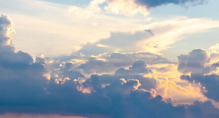 Panorama of blue sky with fluffy clouds at sunset