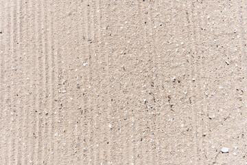 Fototapeta premium Sand beach background with Truck trail on cleaning surface