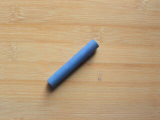 Blue oil pastel stick kept on wooden table