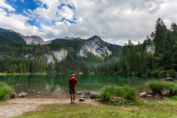 Hiker enjoying the view at Tovel Lake in South Tyrol, Italy