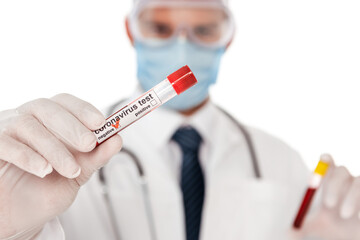 Selective focus of doctor in medical mask showing test tube with blood sample and coronavirus...