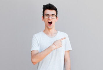 Man surprised shows on your product .Handsome guy with stylish hairstyle points in the side ....