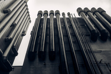ventilation pipes and black brick wall of tallinn building for dark background or wallpaper